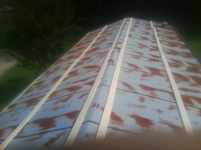Rusted metal roof panels with new wood purlins before replacement — Storm Damage Roof Repair in North Sioux City by Roofing Brothers