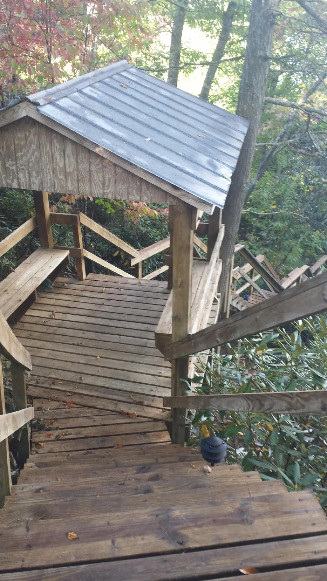 Metal roofed shelter over wooden steps on a wooded walkway — Skylight Repair & Installation work by our crew in North Sioux City