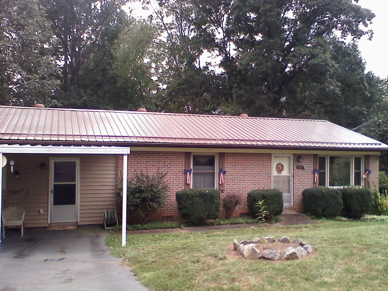 Bronze metal roof and carport on a brick ranch home — Roof Repair work by our crew in North Sioux City